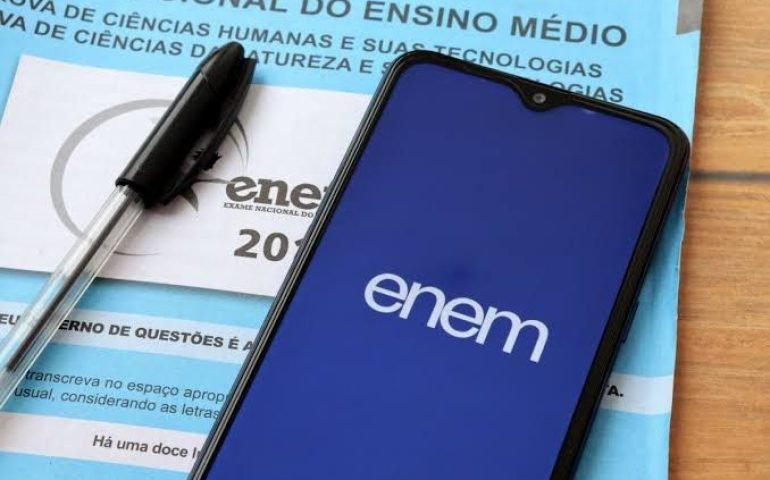 Imagem de uma prova do Enem e um celular no site da prova