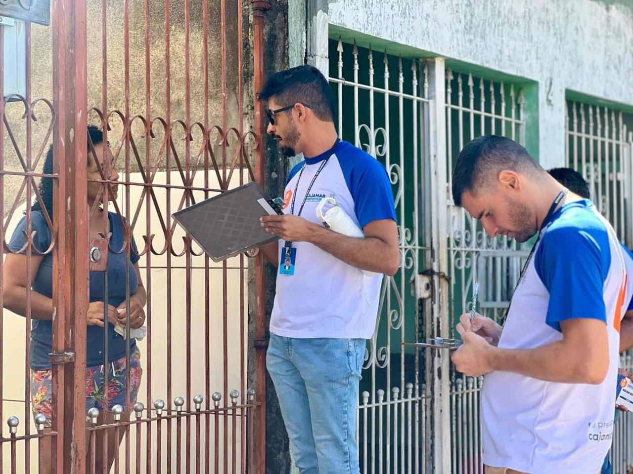Imagem de servidores da Prefeitura de Cajamar realizando a selagem dos imóveis para o processo de regularização fundiária