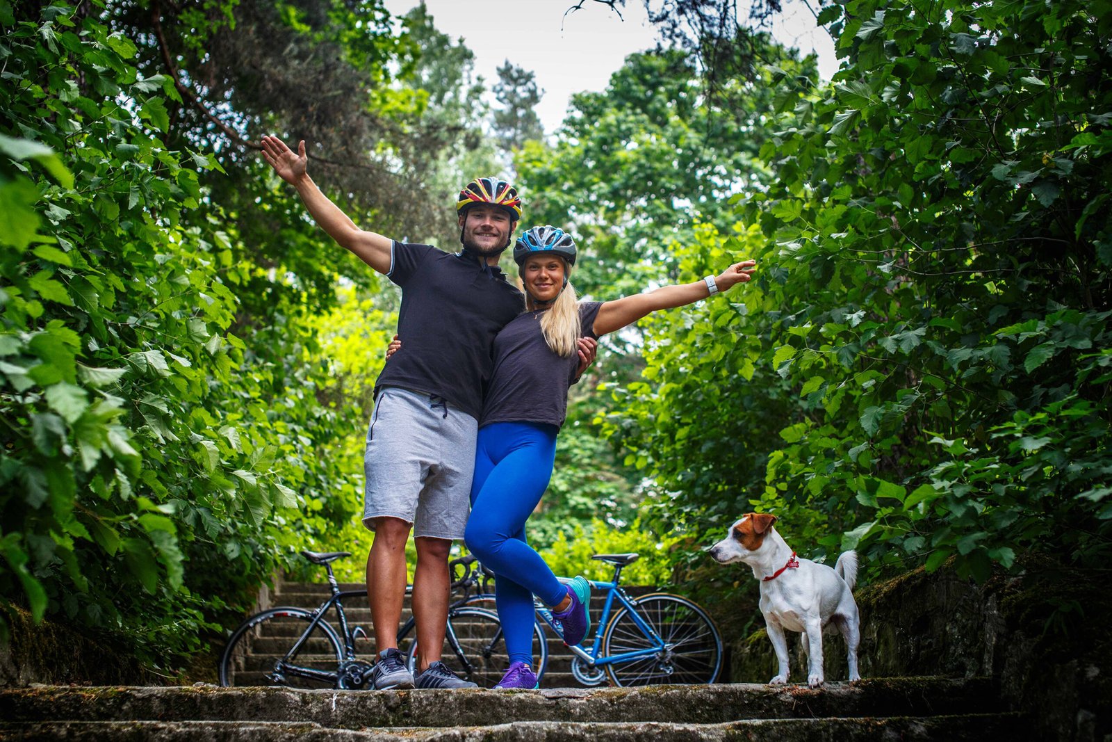 Casal e cachorro fazendo turismo na natureza.